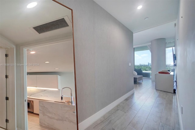 hallway featuring sink and light hardwood / wood-style floors