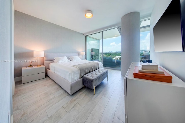 bedroom featuring light hardwood / wood-style flooring, floor to ceiling windows, and access to exterior