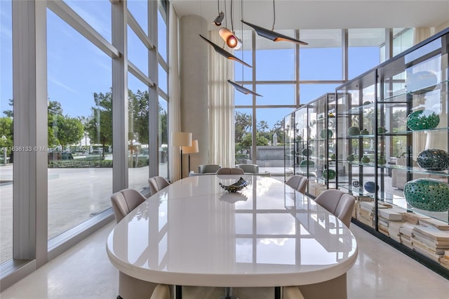 dining room featuring a high ceiling and floor to ceiling windows