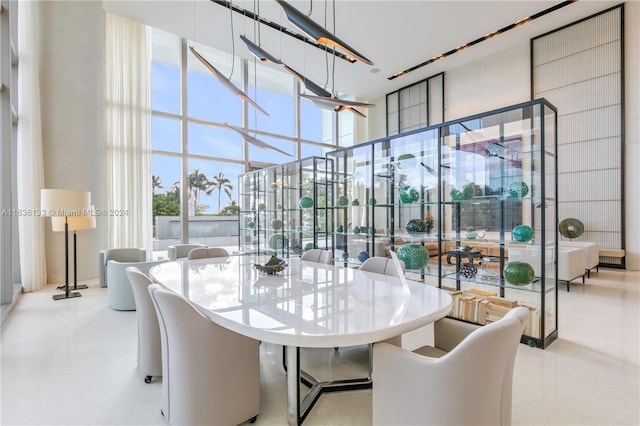 dining space featuring a towering ceiling and floor to ceiling windows