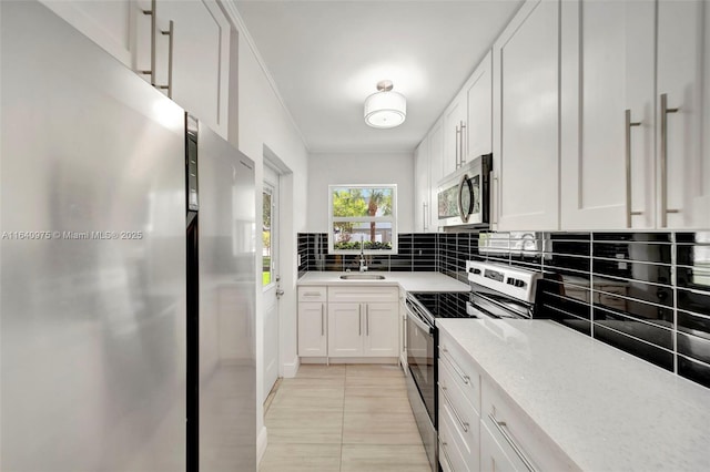 kitchen with decorative backsplash, appliances with stainless steel finishes, light stone countertops, light tile patterned floors, and white cabinetry