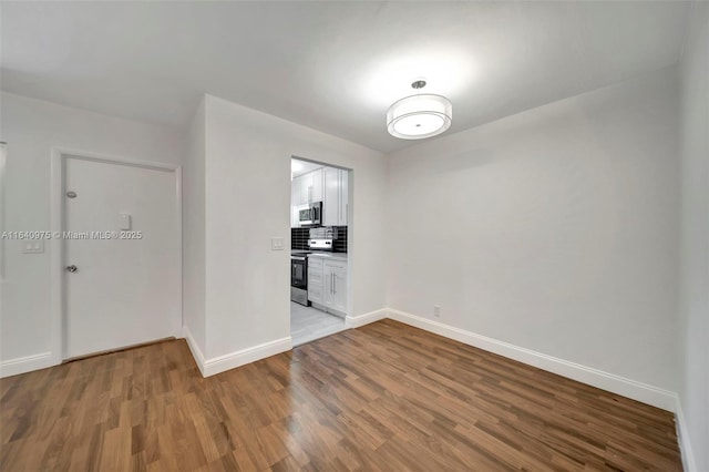 unfurnished room with wood-type flooring