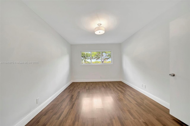 empty room with dark hardwood / wood-style flooring