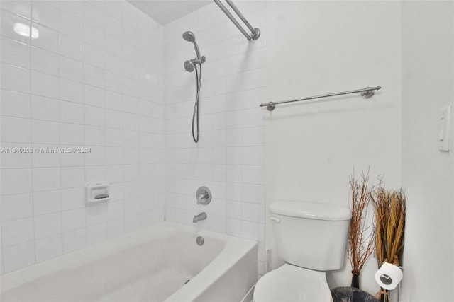 bathroom featuring tiled shower / bath and toilet