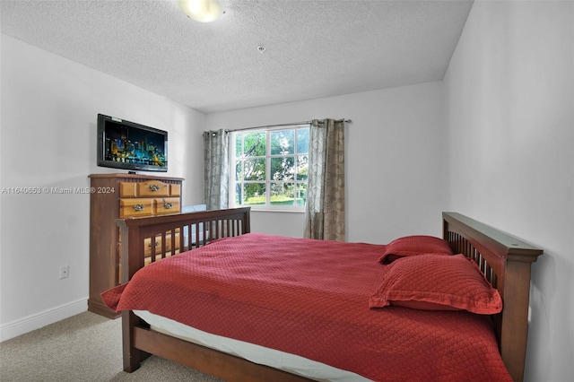 bedroom featuring carpet and a textured ceiling