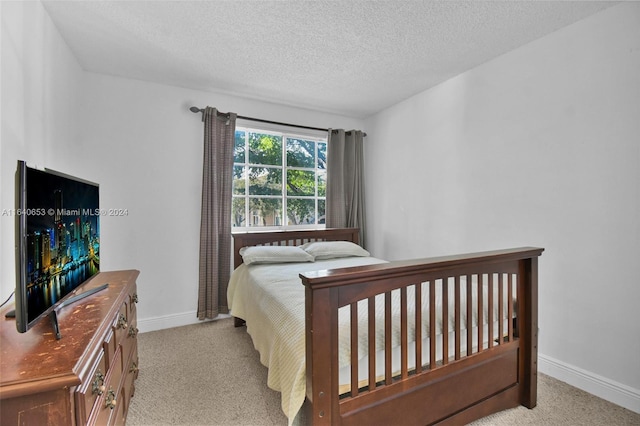 bedroom featuring light carpet and a textured ceiling