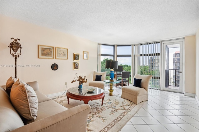 living room with light tile patterned flooring, plenty of natural light, a textured ceiling, and a wall of windows