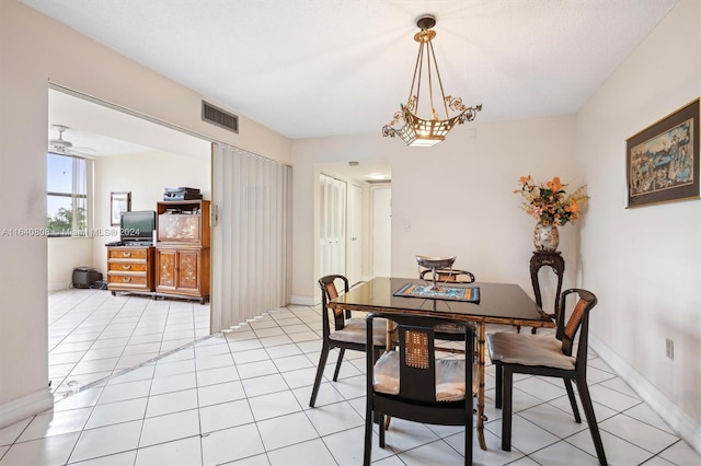 tiled dining area with ceiling fan