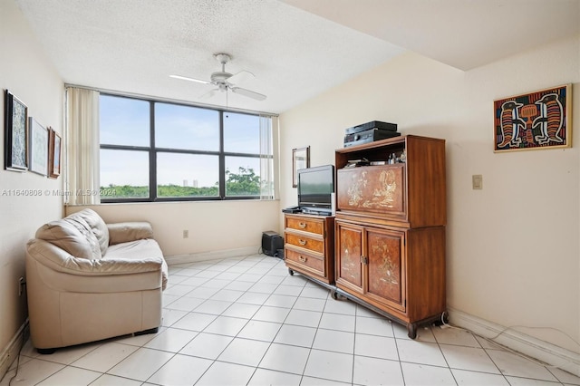 sitting room with a textured ceiling, ceiling fan, and light tile patterned flooring