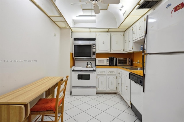 kitchen with light tile patterned flooring, sink, white cabinetry, white appliances, and ceiling fan