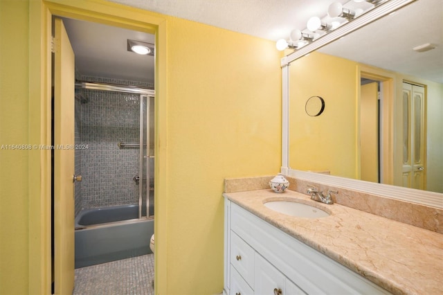 full bathroom with bath / shower combo with glass door, toilet, and vanity