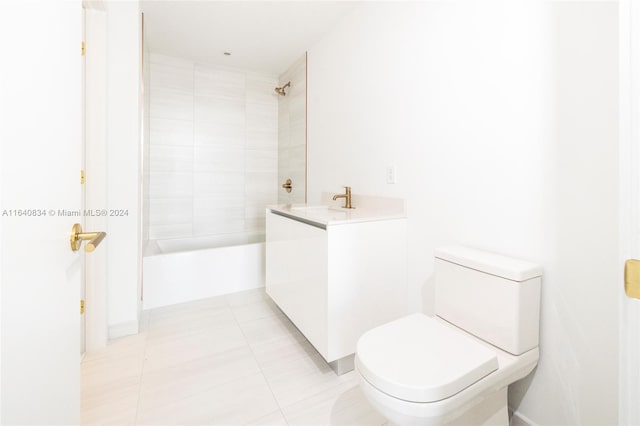 full bathroom featuring tile patterned flooring, tiled shower / bath, toilet, and vanity