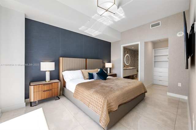 bedroom featuring baseboards, a spacious closet, visible vents, and light tile patterned flooring