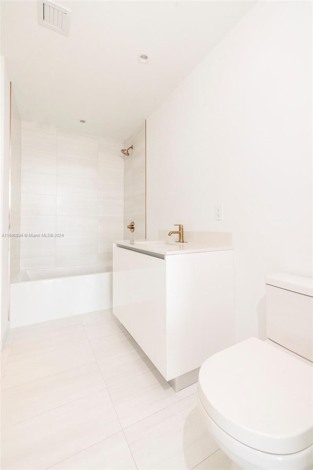 full bathroom with tile patterned flooring, toilet, tiled shower / bath combo, and vanity