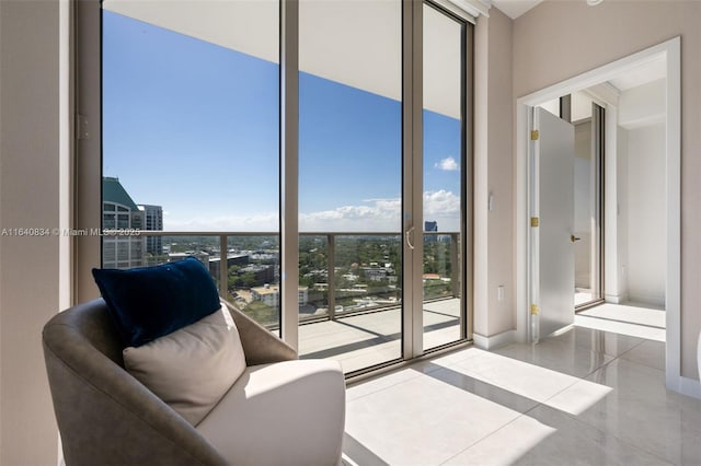 interior space with expansive windows, tile patterned flooring, and baseboards