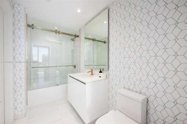 full bathroom featuring toilet, shower / bath combination with glass door, tile patterned flooring, vanity, and tile walls