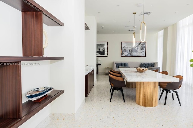 dining area with breakfast area, visible vents, and light speckled floor