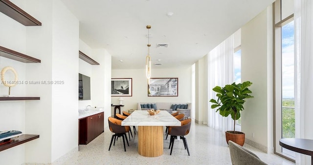 dining area with light speckled floor, plenty of natural light, and visible vents