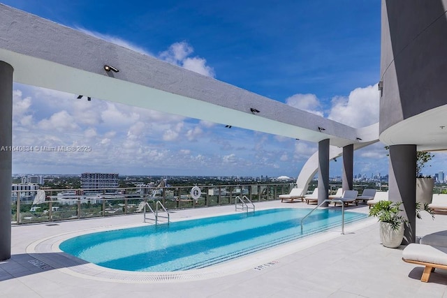 community pool featuring a view of city and a patio area