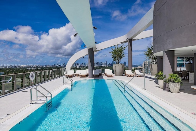 pool with a patio area and a city view