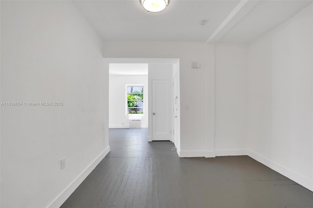 spare room featuring dark hardwood / wood-style flooring and a wall mounted air conditioner