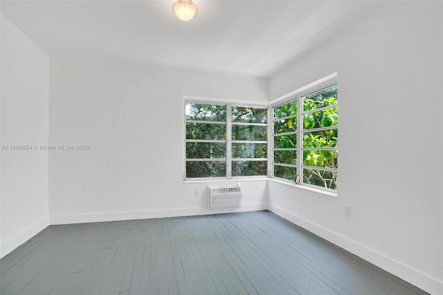 spare room featuring hardwood / wood-style flooring and a wall mounted AC