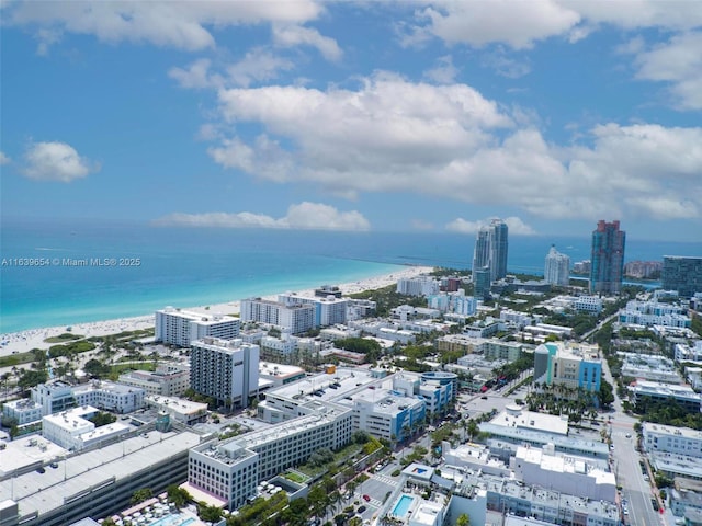 birds eye view of property featuring a water view and a beach view