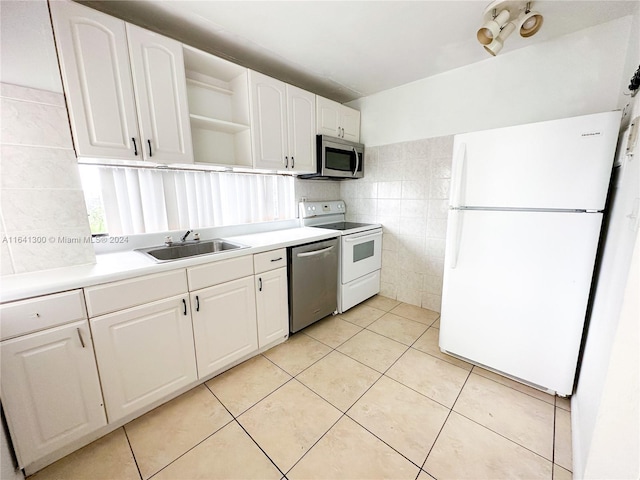 kitchen with white cabinetry, appliances with stainless steel finishes, light tile patterned flooring, tasteful backsplash, and sink