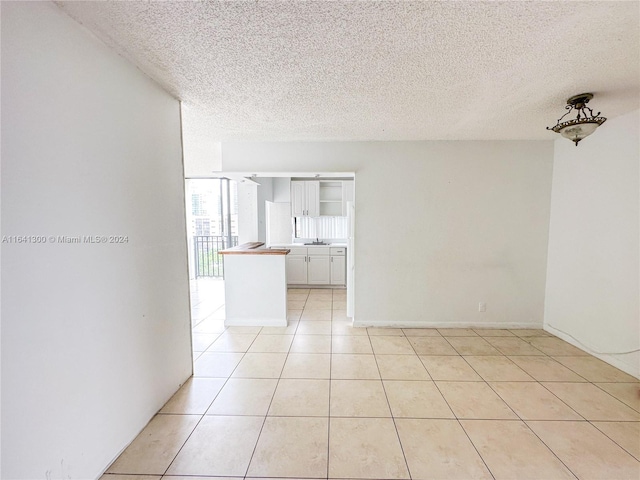 interior space with light tile patterned flooring and a textured ceiling