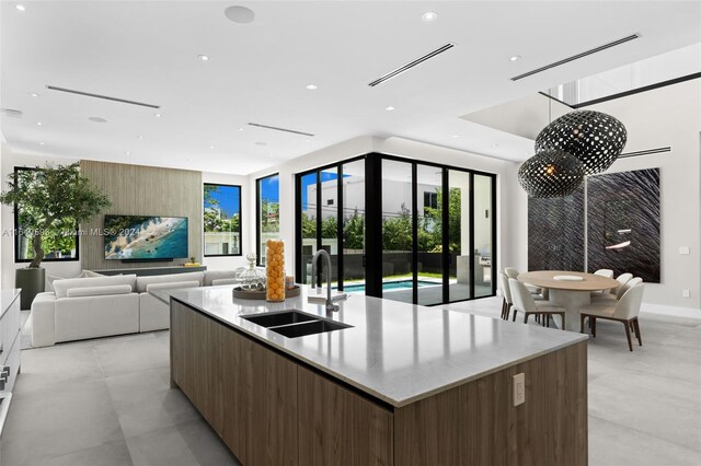 kitchen featuring light tile patterned floors, sink, and a kitchen island with sink