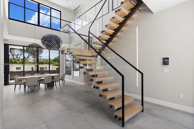 stairs featuring tile patterned flooring and a high ceiling