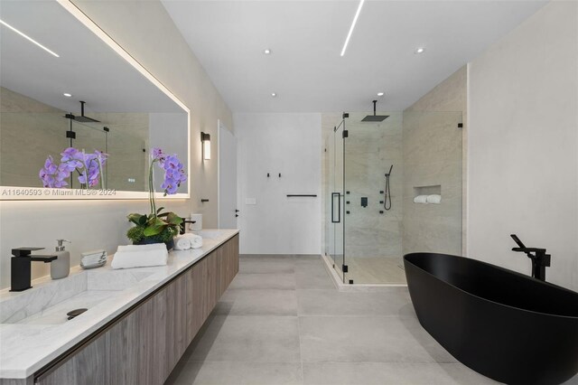 bathroom featuring tile patterned floors, vanity, and a shower with door