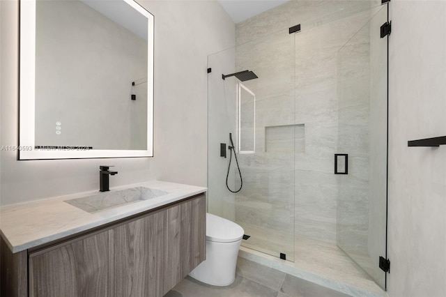 bathroom with a shower with shower door, vanity, tile patterned floors, and toilet