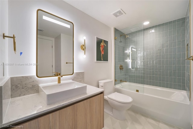 full bathroom featuring tiled shower / bath, vanity, toilet, and tile patterned flooring