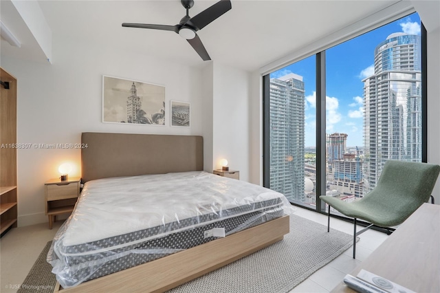 bedroom with ceiling fan, access to outside, and expansive windows