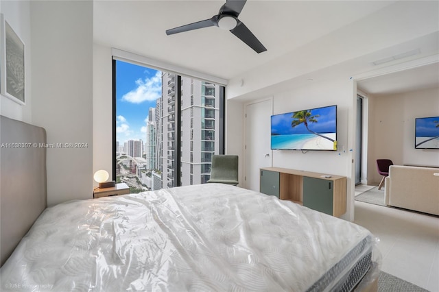 bedroom featuring ceiling fan, light tile patterned floors, and access to exterior