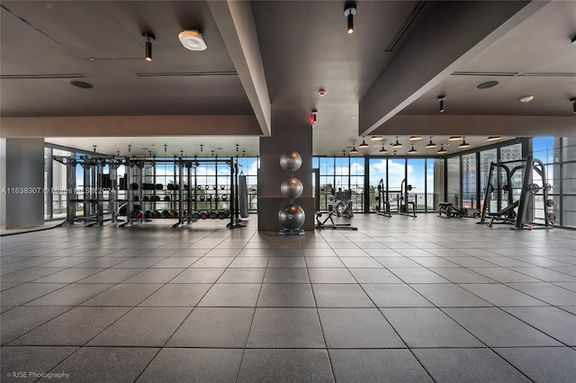 workout area with expansive windows and light tile patterned floors