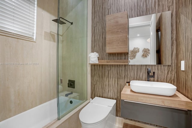 full bathroom featuring toilet, vanity, and combined bath / shower with glass door