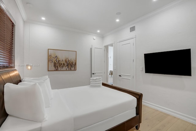 bedroom featuring light hardwood / wood-style flooring and ornamental molding