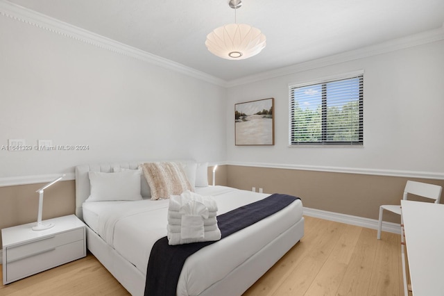 bedroom with ornamental molding and light hardwood / wood-style flooring