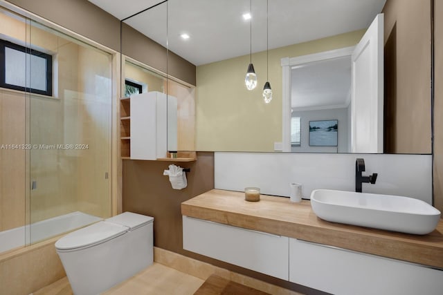 full bathroom with vanity, toilet, and enclosed tub / shower combo