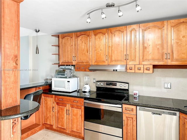 kitchen featuring stainless steel appliances, decorative light fixtures, light tile patterned floors, and rail lighting