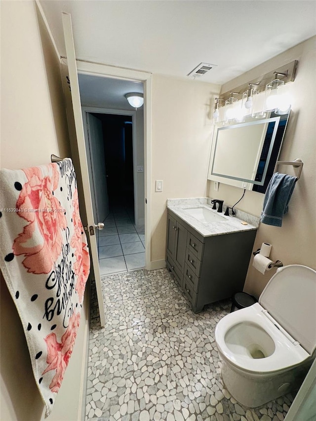 bathroom featuring toilet, vanity, and tile patterned floors