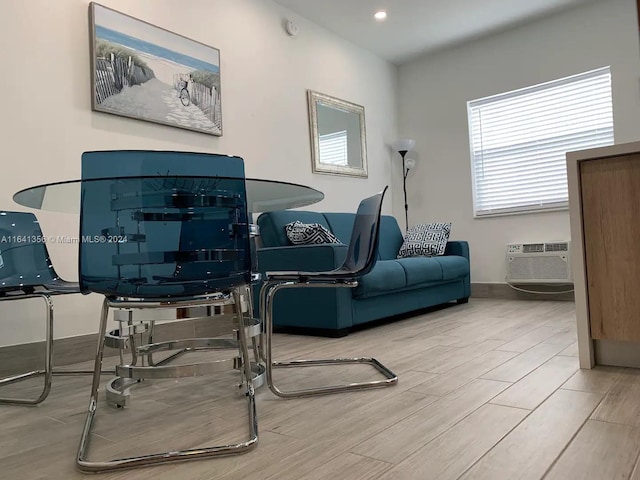 office area with an AC wall unit and light hardwood / wood-style flooring