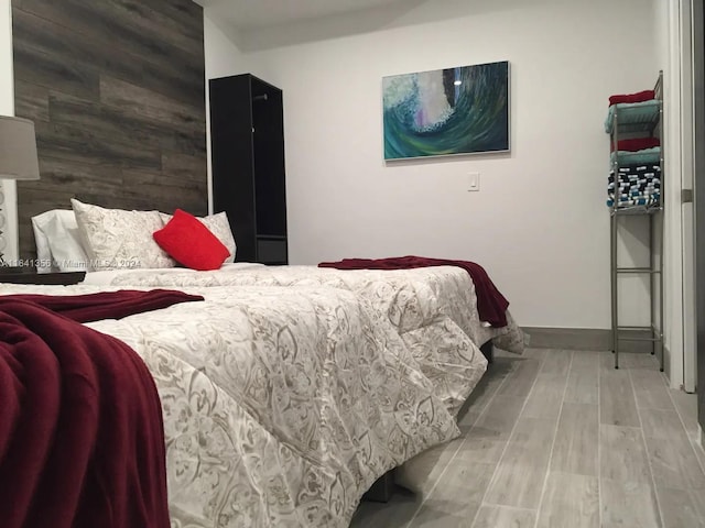 bedroom with wood walls and light hardwood / wood-style flooring