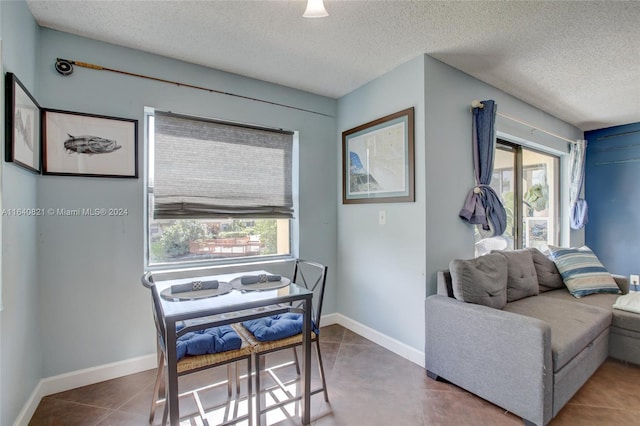 dining area with a textured ceiling, plenty of natural light, and tile patterned floors