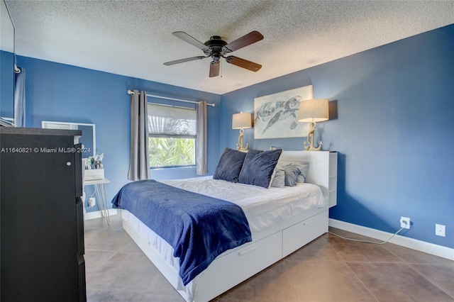 bedroom featuring ceiling fan, a textured ceiling, and tile patterned floors