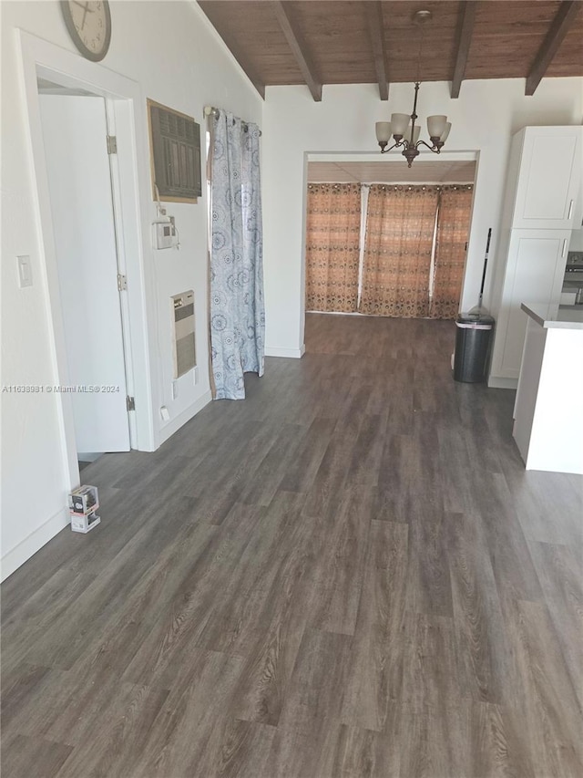 unfurnished living room with a notable chandelier, dark wood-type flooring, heating unit, wood ceiling, and vaulted ceiling with beams