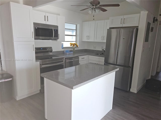 kitchen featuring appliances with stainless steel finishes, hardwood / wood-style flooring, and white cabinets