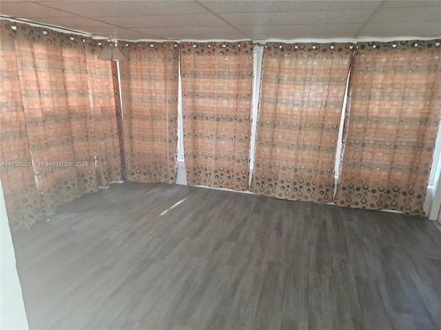 spare room with hardwood / wood-style floors and a drop ceiling